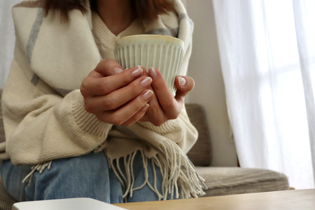 温かい飲み物を持つ女性
