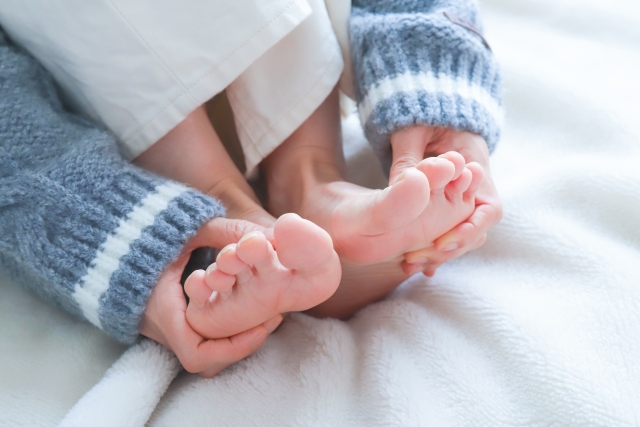 冷たい足先を触る女性