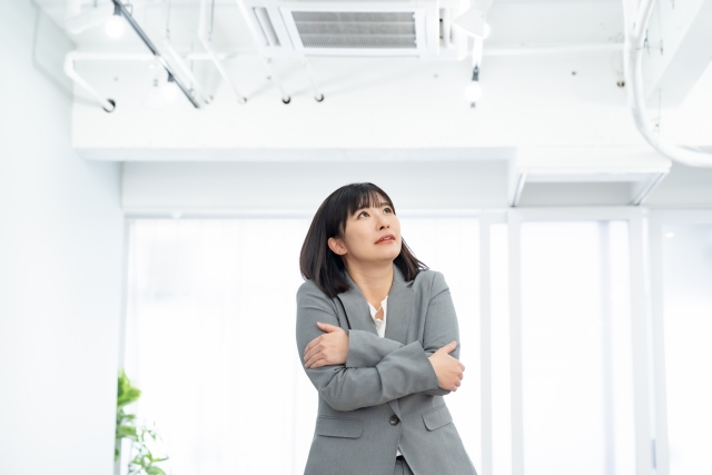 エアコンで寒さを感じる女性