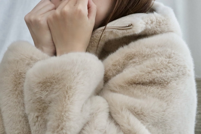 ファーを着た寒そうな女性