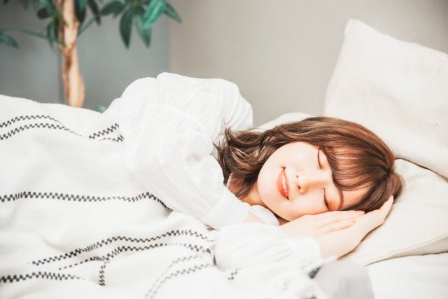 ベッドルームで気持ちよさそうに眠る女性